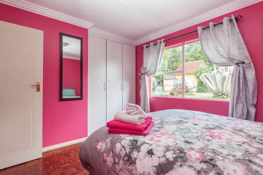 Bedroom with built-in cupboards and view onto garden