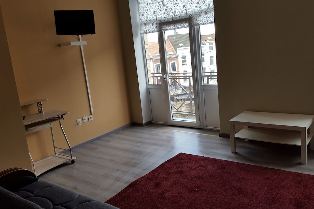 Appartement de gauche situé au 3ème étage : salle de séjour avec 2 canapés-lits, une cuisine équipée et une télévision.