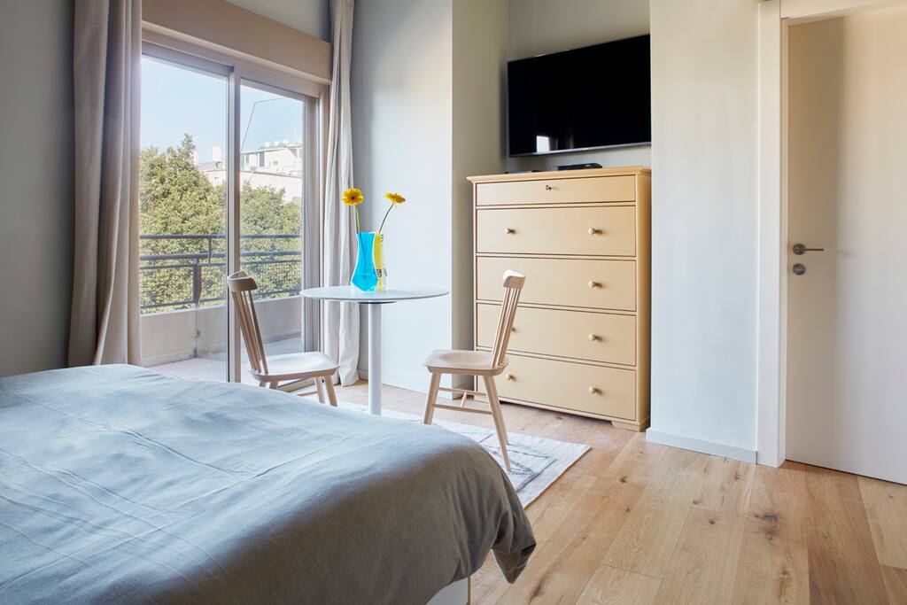 A glance from the bed to the eating/working table, vast drawer, 50 inches TV and the lovely terrace.