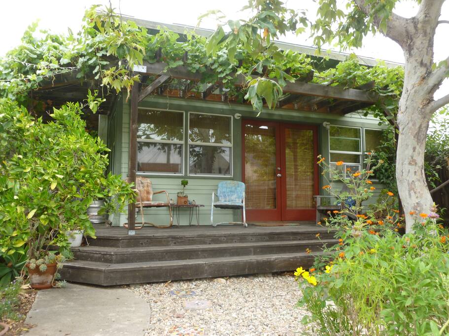 Shaded seating includes Adirondack chairs and rocking chairs on the porch.
