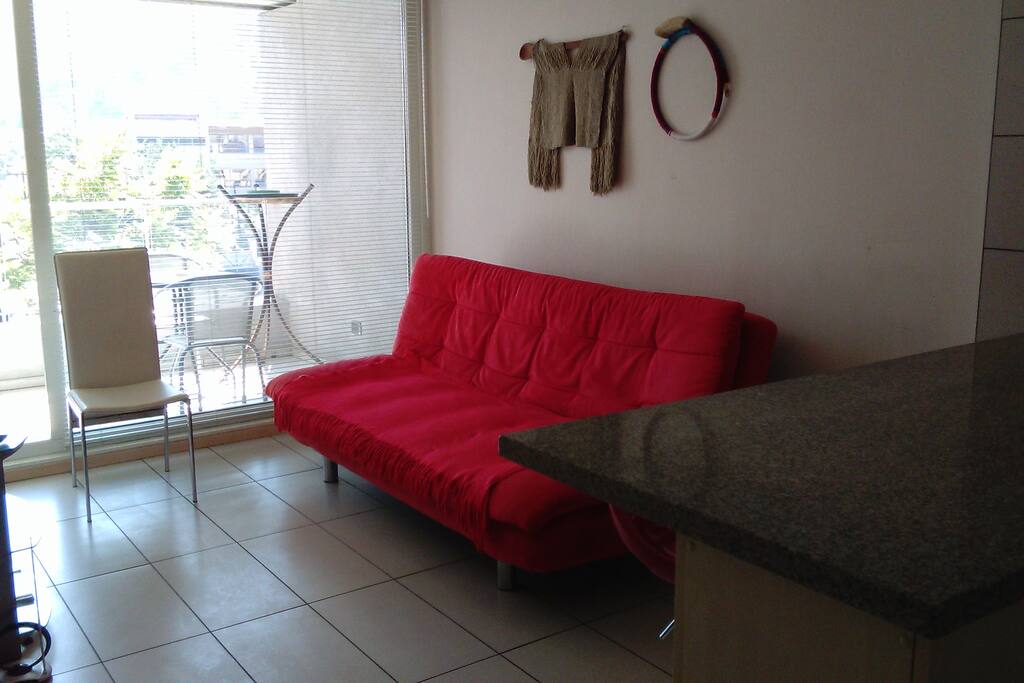 Sala de estar con futon de dos plazas y vista a la terraza.
