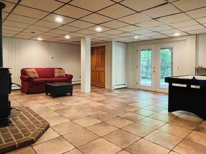 地下室游戏室，户外通往河景的阳台。 沙发配有折叠双人床。