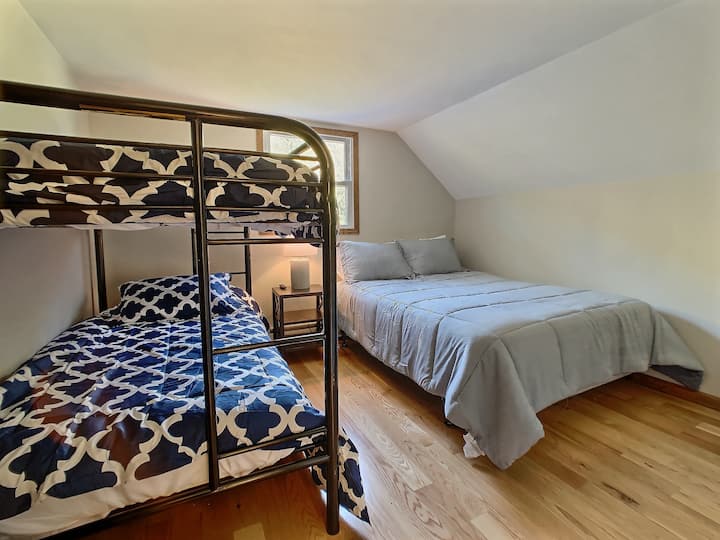 Cama tamaño queen con literas individuales, con TV. Perfecto para niños.