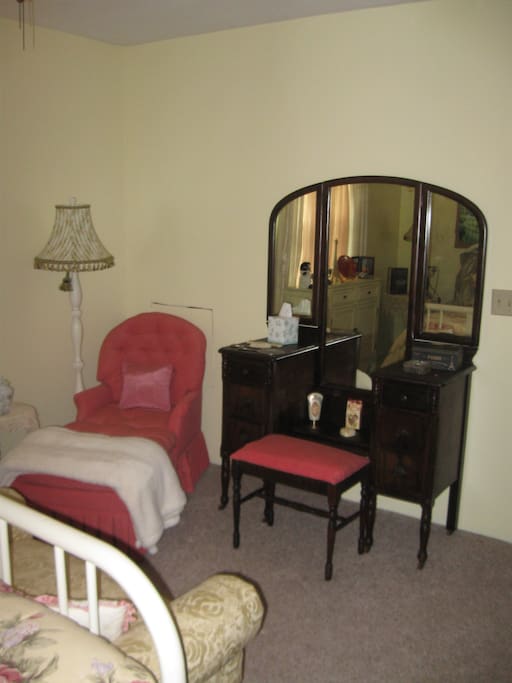 Chaise lounge chair next to vanity.