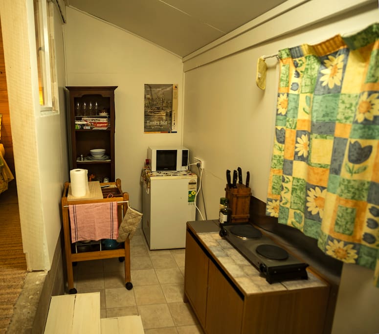 The newly enclosed (August 2016) kitchen annexe showing the cooker and crockery cupboard, bar fridge with small freezer, and the pots/pans/implements trolley.