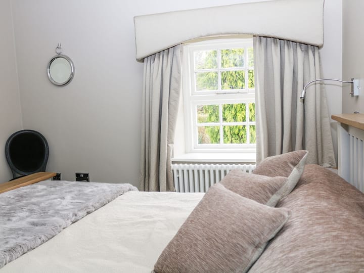 Спалня с щедра размер и удобно двойно легло с бяло качество 100% памучно спално бельо. Съвременен бял плъзгащ се гардероб, предлагащ много гардероб и отворено място в чекмеджето. Неговите и нейните гардероби.