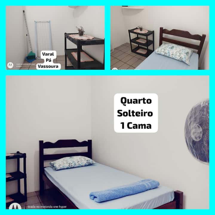 Habitación individual 1 cama, pequeña, con ropa de cama , toallas y ventilador de pie. 