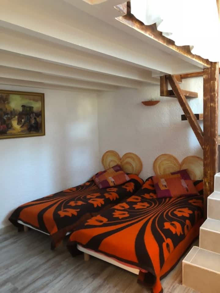 מתחת לקומת הביניים, אזור השינה השני מצויד בשתי מיטות נפרדות למבוגרים הפונות לטלוויזיה בגובה רגיל 