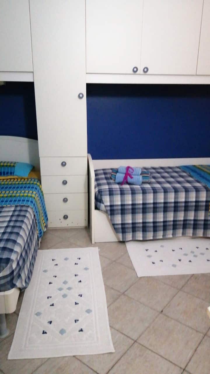 Dhomë me gardërobë, 2 krevate tek dhe 1 krevat tek me hyrje më vete në banjë 