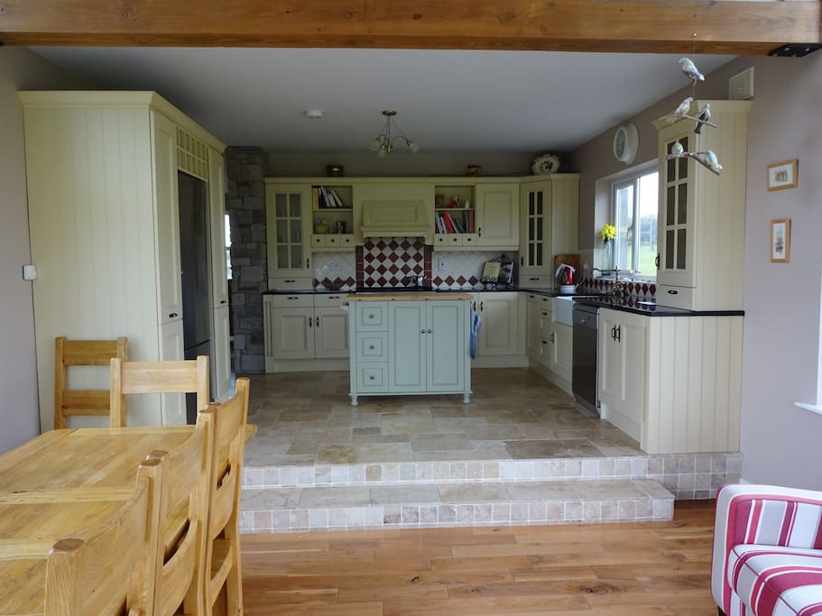 The kitchen opens into a sunroom dining area