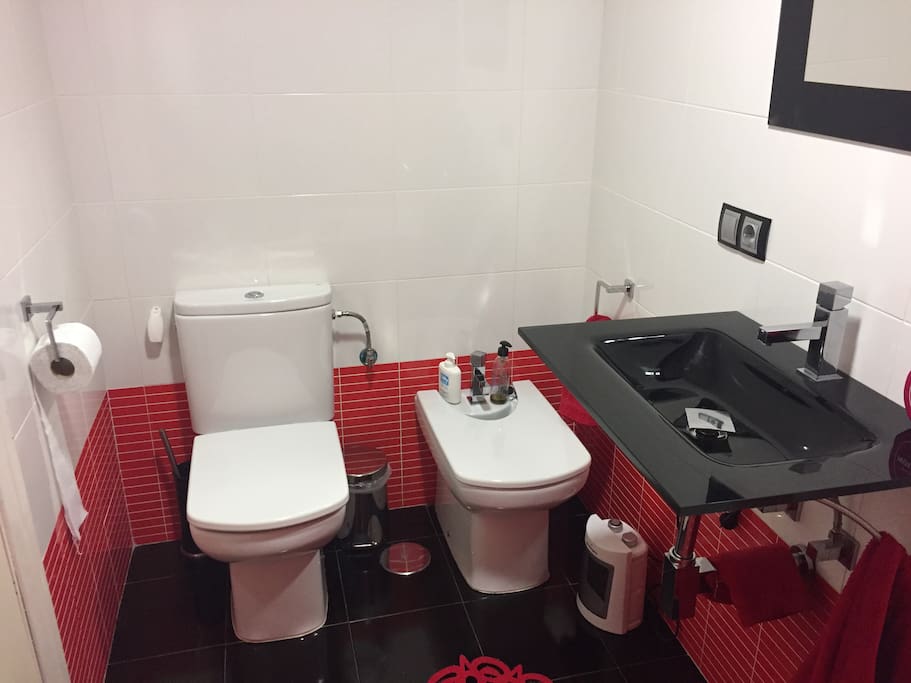 Cuarto de baño completo con espejo.