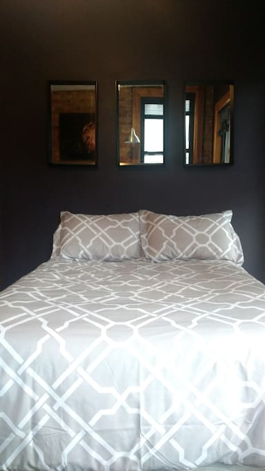 The bed has a down comforter with duvet cover and 4 pillows. The mattress is a full size pillow top on a box spring. It is in a soft (it makes no crinkly noise) fully protective waterproof case with mattress pad and high thread count cotton sheets on top. Mattress pad, sheets and duvet cover are washed between every guest.