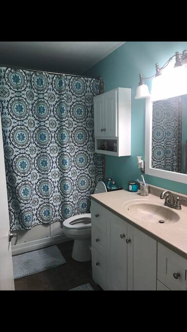Upstairs bathroom complete with jacuzzi tub, fresh towels, and storage space.