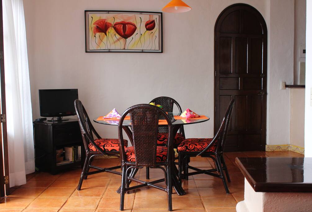 Dining room and full kitchen with complete cooking and serving items.