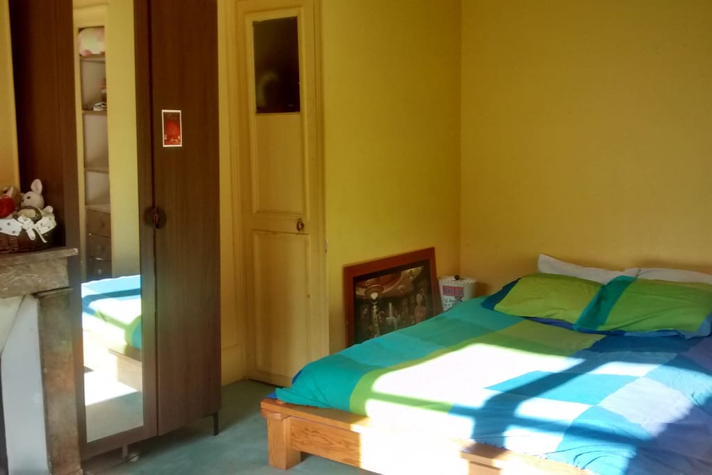 Une chambre spacieuse et lumineuse, avec un lit double confortable, un placard et une penderie à disposition des invités.