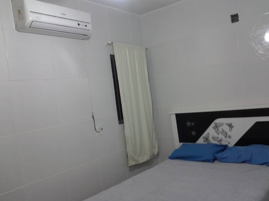 quarto casal com ar condicionado split e ventilador de teto
