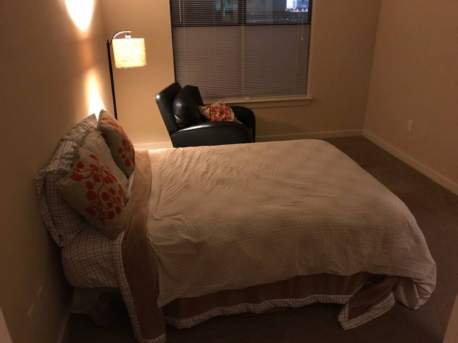 Spacious private bedroom with picture window, BarcaLounger reclining leather chair, cozy floor lamp and 20 ft ceilings
