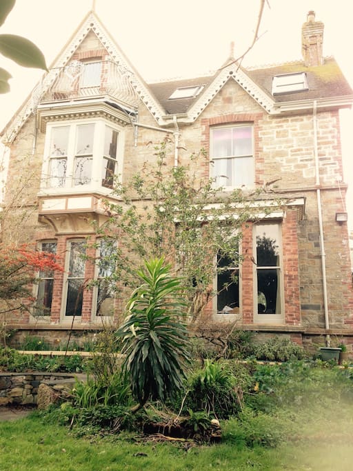 The house! 2 minutes walk to the sea Penzance Bay. 6 person Hot tub in a garden that feels private due to tall mature trees. Trampoline 14 ft diameter, barbecue area, patio, conservatory, pretty Victorian porch, secret wooden hut with log burner.
