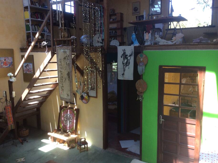 vista para quarto embaixo com cama de casal, e escada que leva para mezanino.