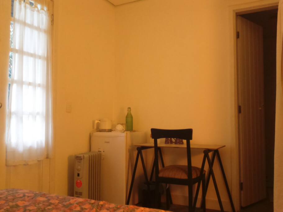 Bedroom with minifridge, desk, heater and water heater
