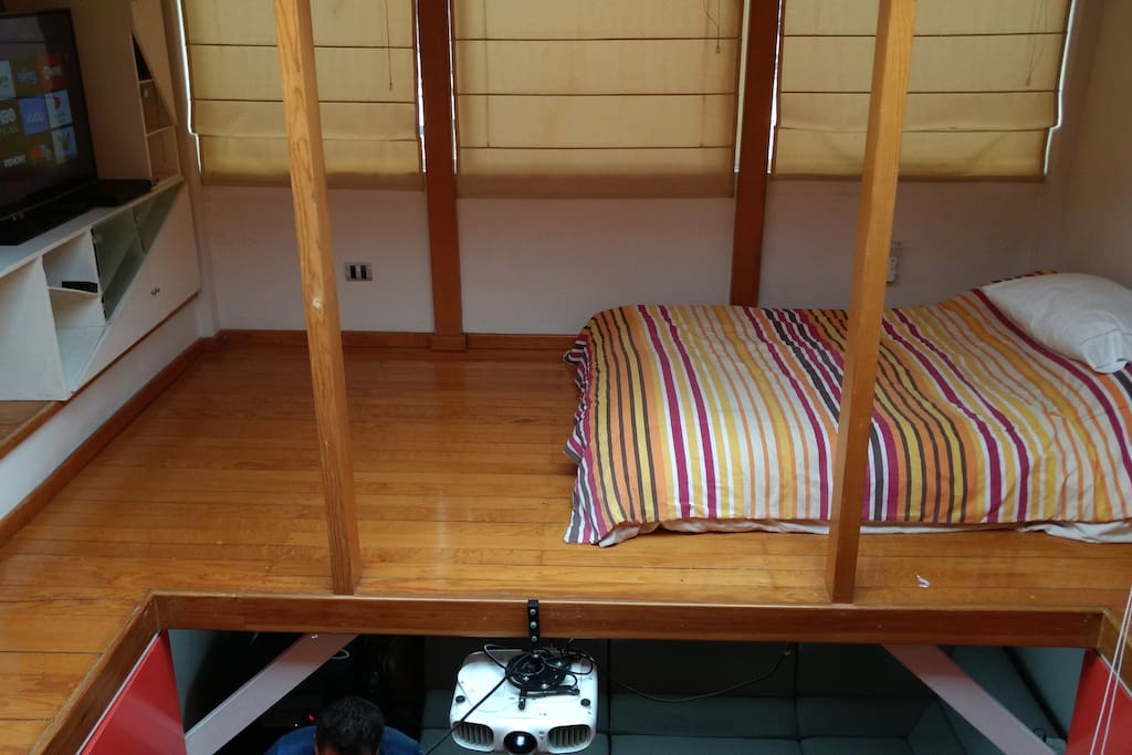 Room with double bed, television and living room