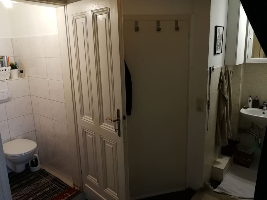 Blick aus dem Flur auf Bad Teil 1 (Waschnische), Eingangstür und Bad Teil 2 (Toilette)
