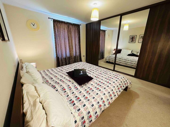 ห้องนอนชั้นแรกพร้อมเตียงคิงไซส์และเครื่องนอนที่สะดวกสบายพร้อมตู้เสื้อผ้าบานเลื่อนขนาดเต็มพร้อมโรงเก็บของและกล่องเก็บของ