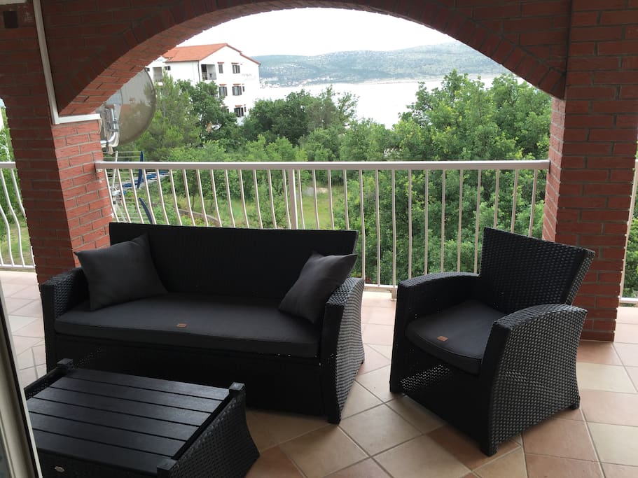 Covered terrace with patio furniture, perfect for escaping the heat or relaxing in the evening