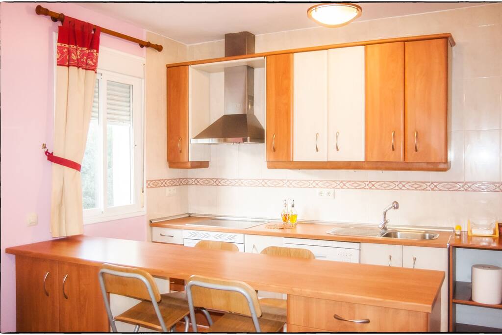 La cocina está totalmente equipada: vitrocerámica, horno, campana, nevera y lavavajillas y con una zona de barra y sillas altas ideal para el desayuno.