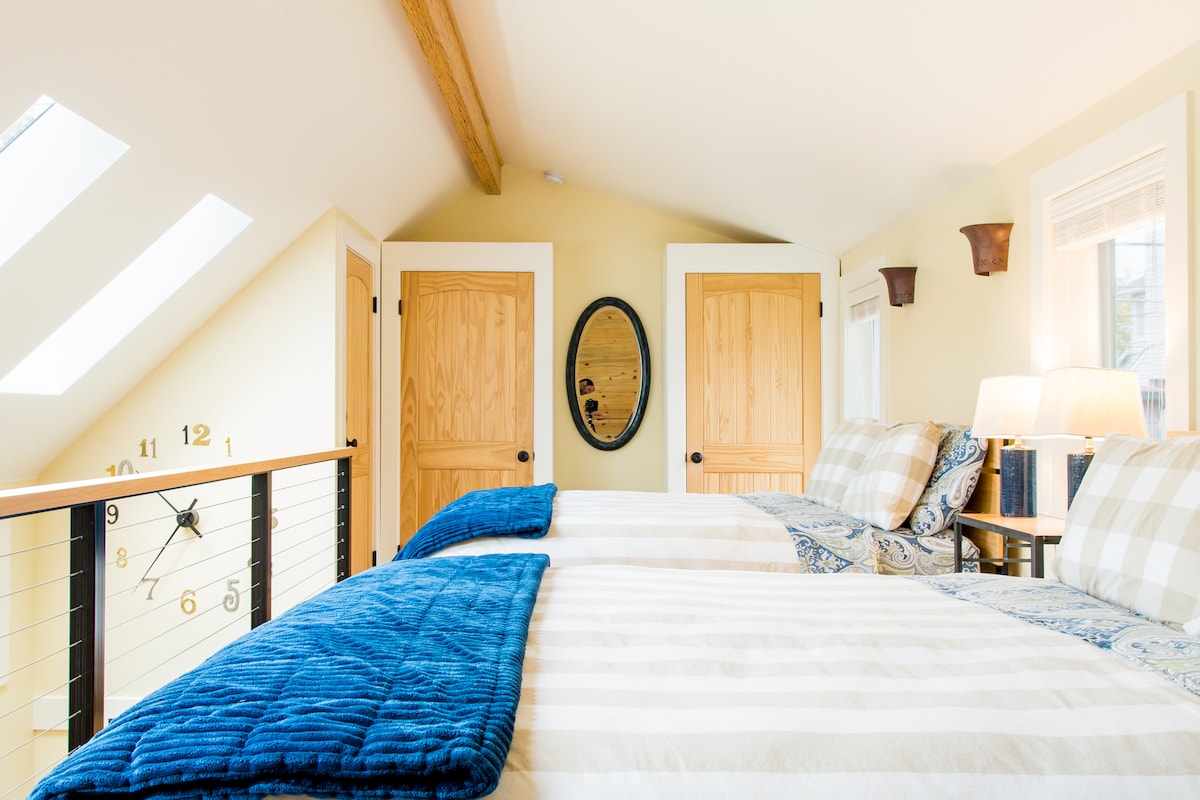 Dormitorio loft con dos camas matrimoniales y unidad de calefacción/aire acondicionado separada.