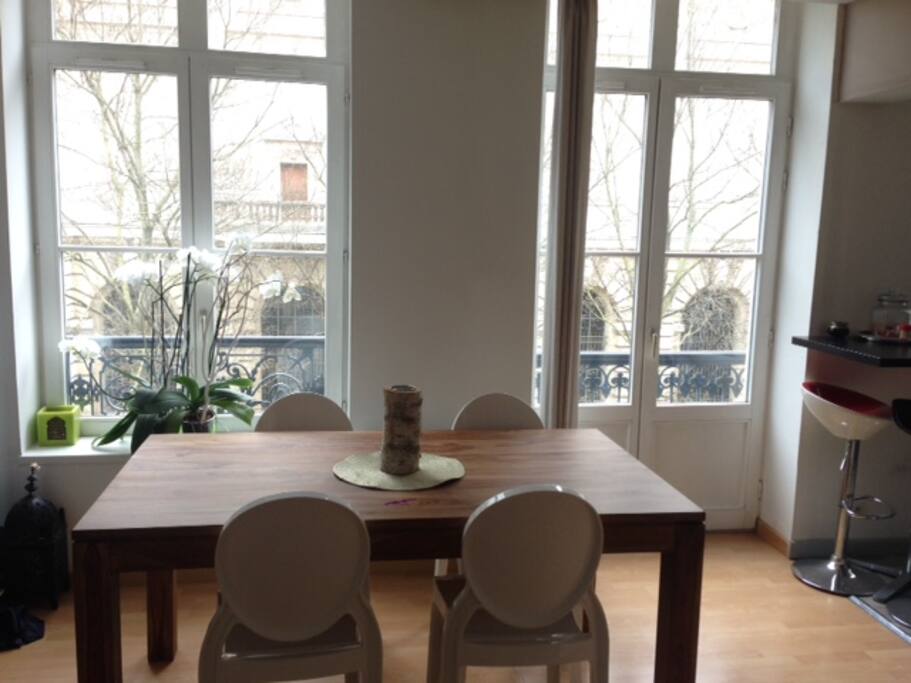 Dans la continuité du séjour, la table à manger avec les fenêtres qui donnent vue sur le musée des beaux-arts