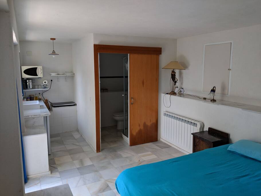 Perspectiva completa del apartamento. Cocina, baño y cama de matrimonio.