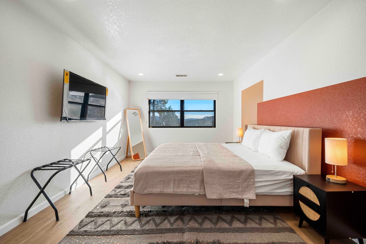- חדר שינה מואר עם מיטת קינג וטלוויזיה חכמה לבידור   - נופים מרהיבים דרך חלון גדול ומנורות חמימות יוצרים מקום מפלט שקט   - מקום אירוח מסוגנן ב-Airbnb, שנועד לנוחות ורגיעה  