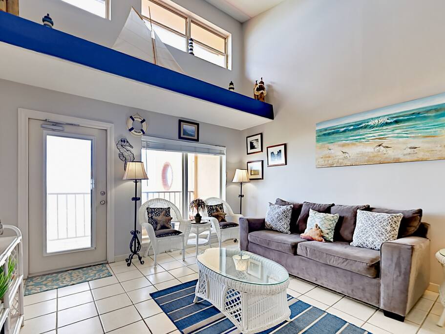 The living room seats 7 and offers balcony access with views of the Gulf of Mexico.