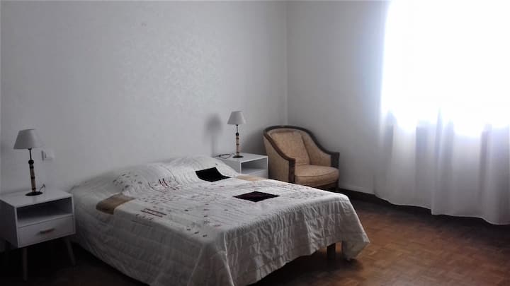 Velika spavaća soba s bračnim krevetom, stočićima i noćnim svjetiljkama, foteljom