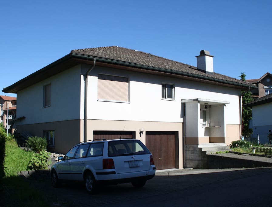 House front with guest parking to the left.