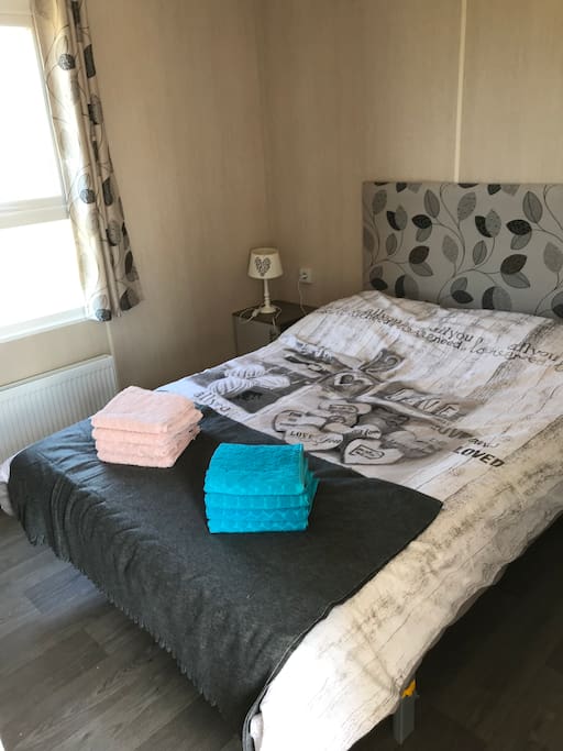 Tweepersoonsbed in sfeervolle slaapkamer.