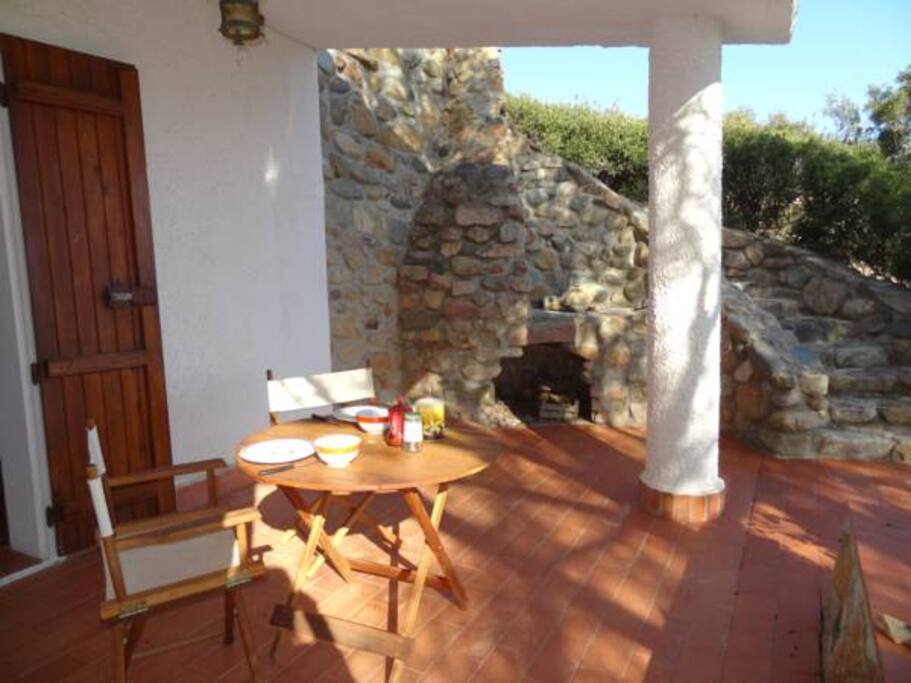 Loggiato con camino barbecue in pietra locale sullo sfondo. La scala sulla destra porta alla camera da letto 4.