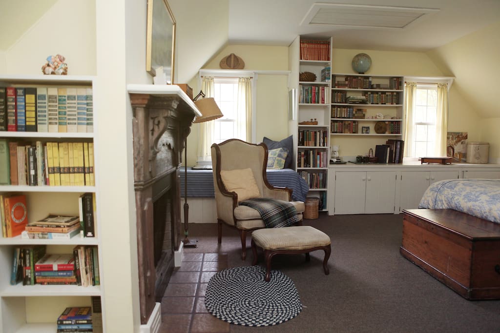 John's room with lots of books to read by the fireplace.