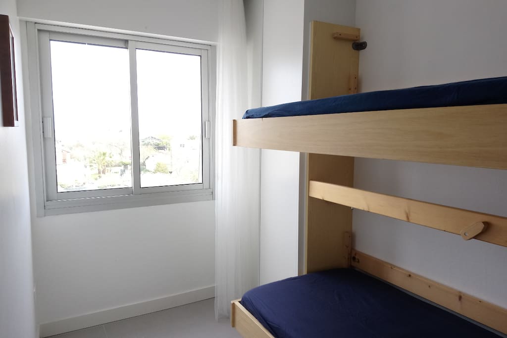 La chambre avec un lit superposé et un grand placard pour ranger les vêtements. Une fenêtre ouvre sur une belle vue sur la mer et la lagune