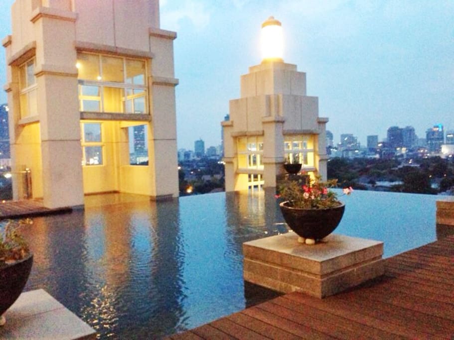 Outdoor rooftop infinity swimming pool at sunset with clear 360degrees view of Jakarta
