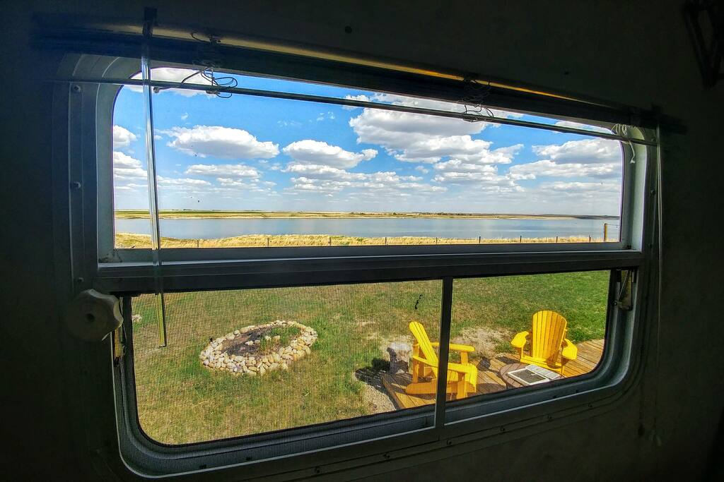 View out east facing window in bedroom with Queen size bed.