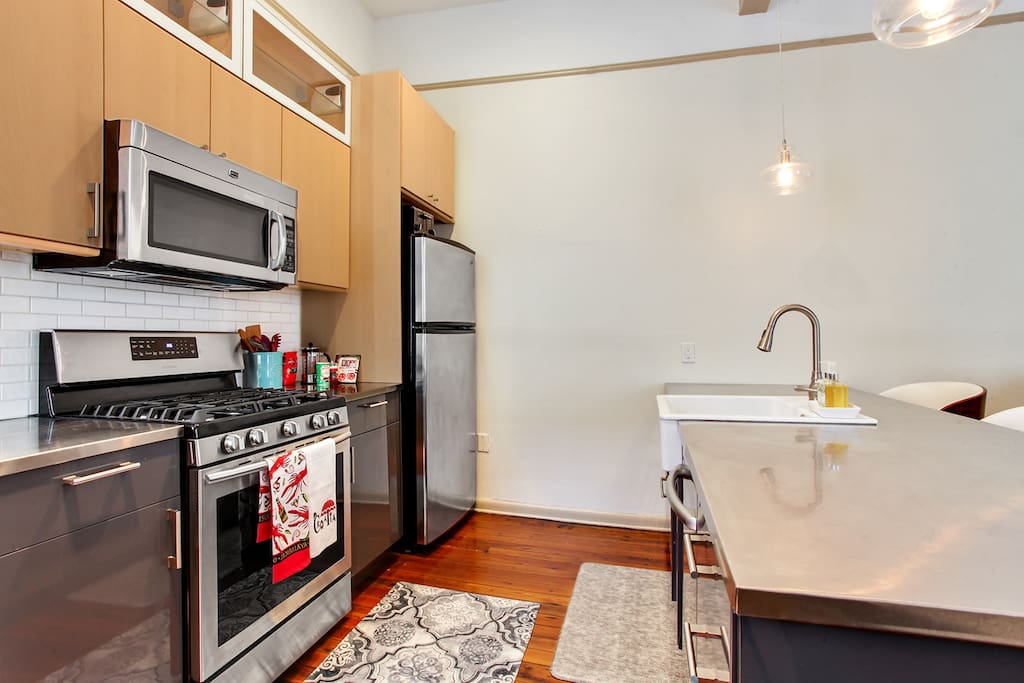 Fully renovated kitchen with stainless steel counters and a farmhouse sink.