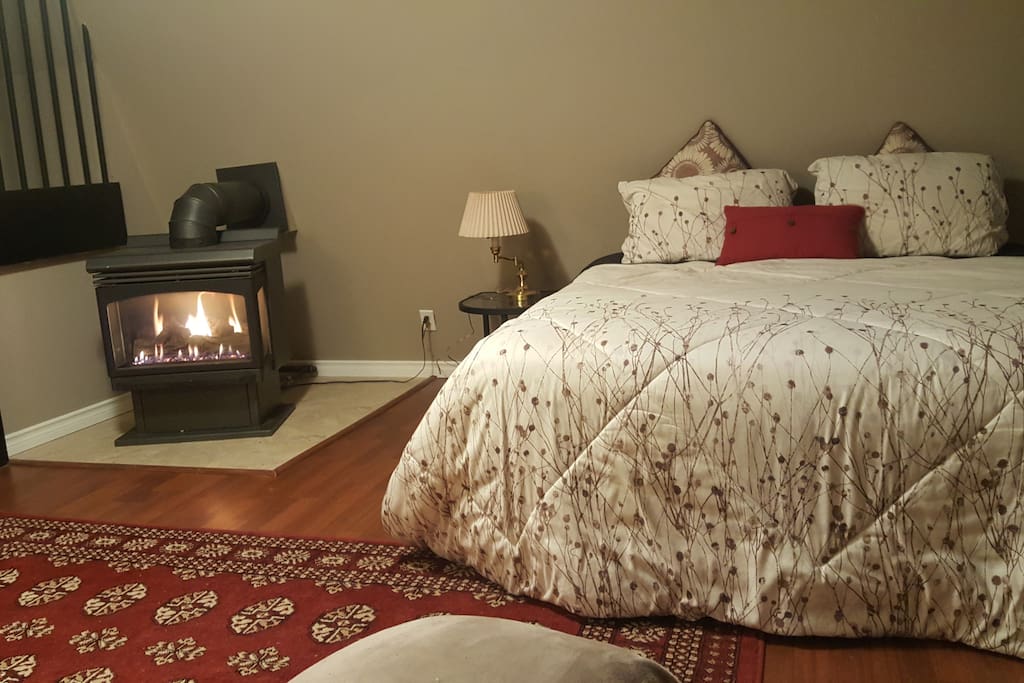 Queen size bed next to the gas fireplace.