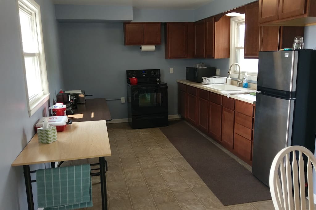 Newly remodeled kitchen with large sink, microwave, double oven burners, toaster, stove and refrigerator.