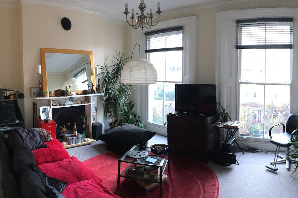 A beautiful sunny room with a balcony through the large windows.
