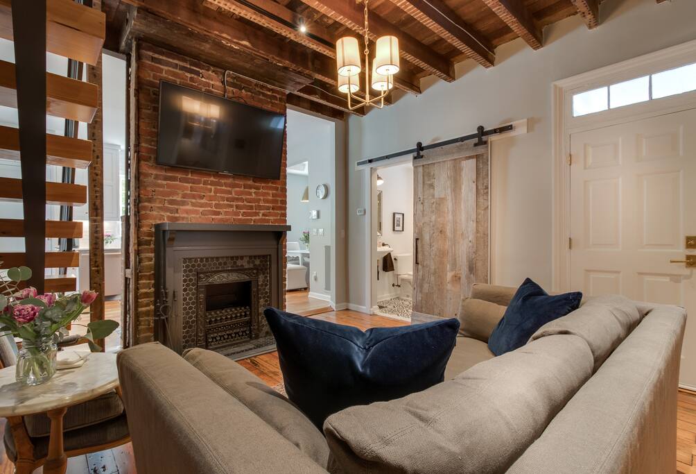 Living room off kitchen which has the Queen size pull out sofa bed, showcases the bathroom with barn door
