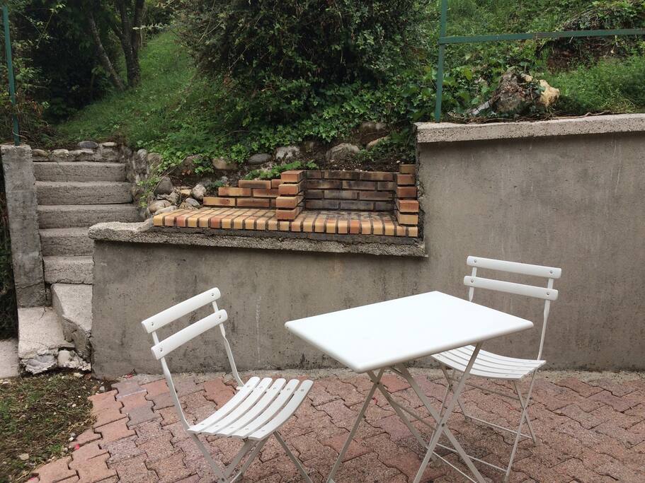 Terrasse extérieure avec barbecue et parasol