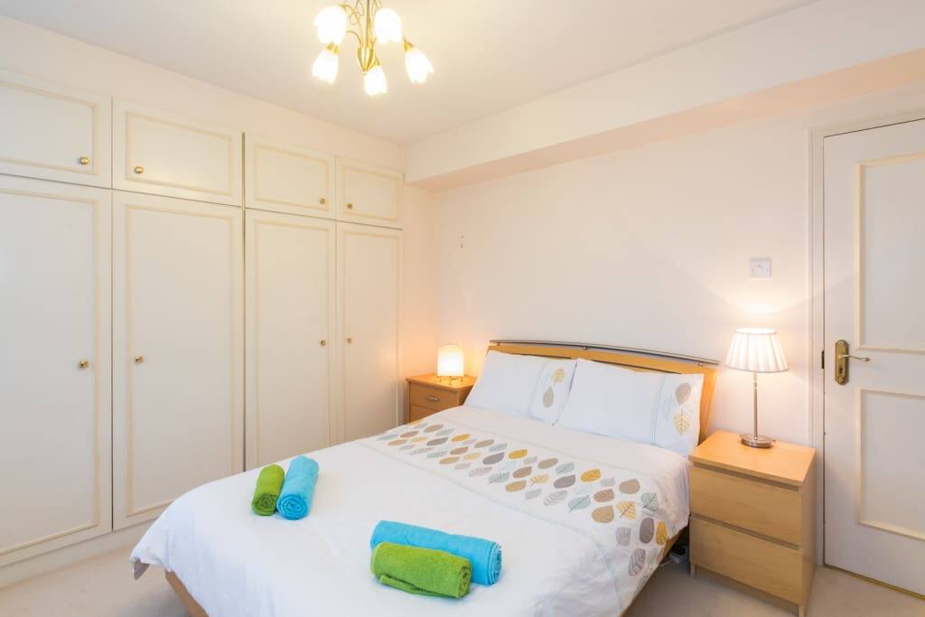First bedroom with king size bed, lots of natural light, and plenty of storage space.