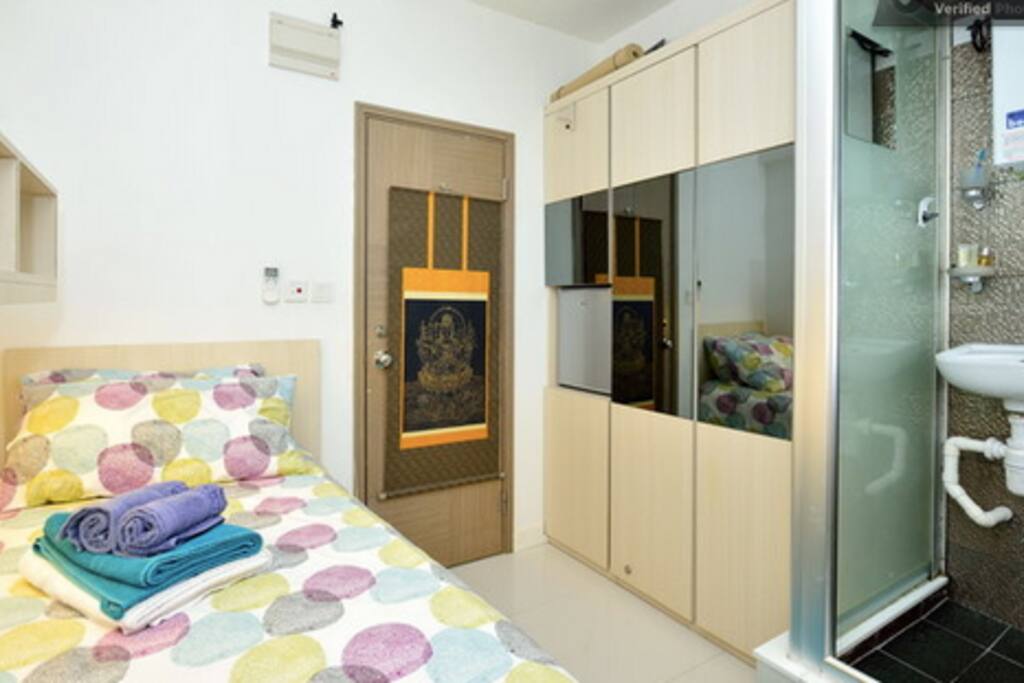 bed, large wardrobe and shower booth toilet in it.